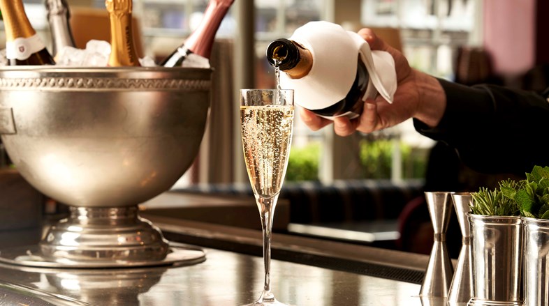 A glass of sparkling wine being poured into a flute