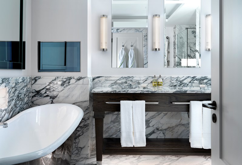 A marble bathroom in the apartments at 9-11 Richmond Buildings featuring a double basin sink and a roll top pewter bath.