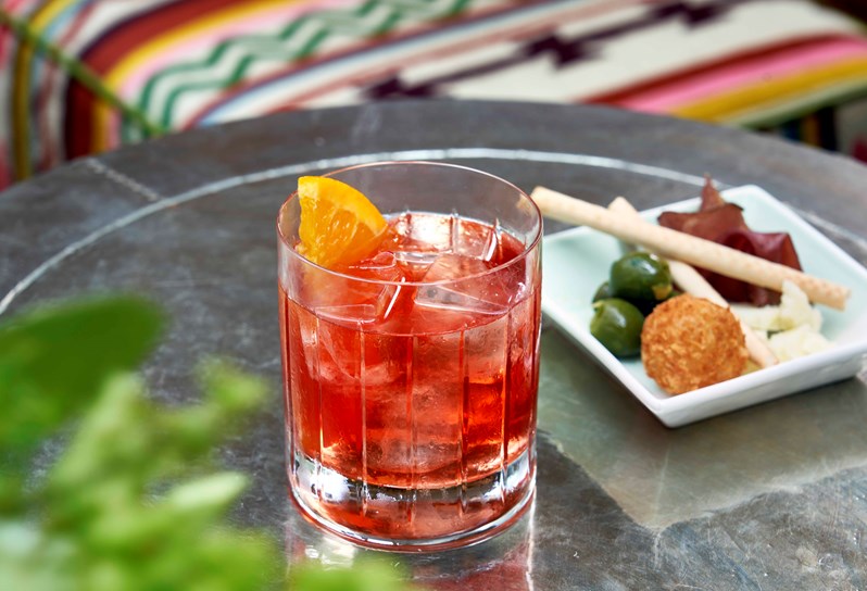 A cocktail and a selection of bar snacks