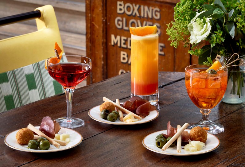 A cocktail and a selection of bar snacks