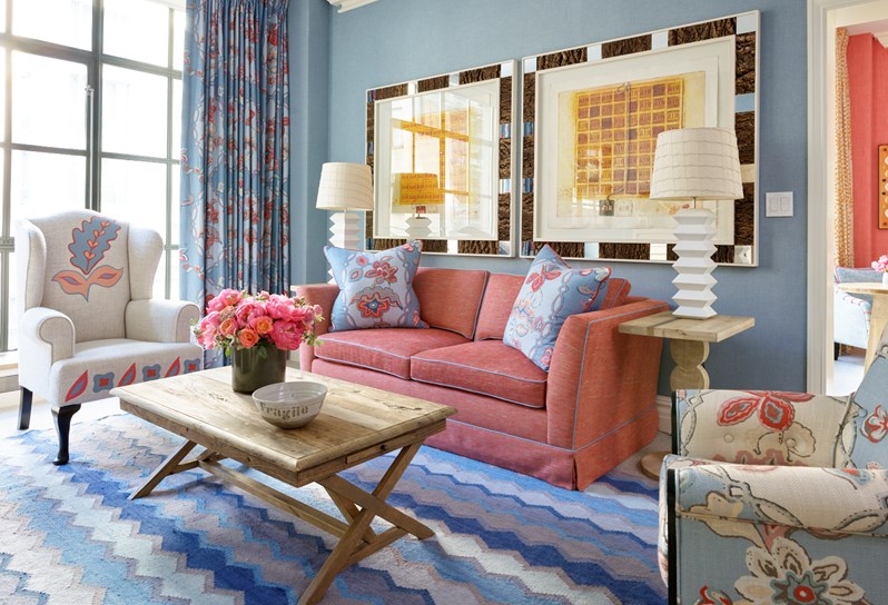 The drawing room of a Corner Terrace Suite which includes a sofa, two armchairs and a decorative rug with a vibrant design