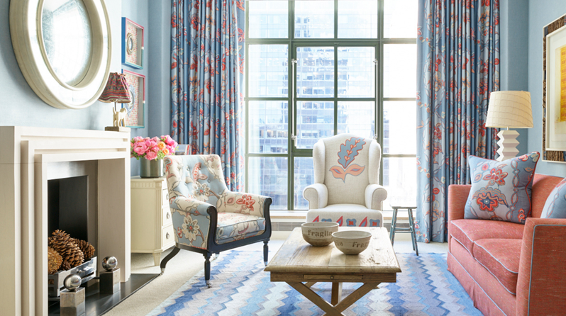 The drawing room of a Corner Terrace Suite which includes a sofa, two armchairs and a decorative rug with a vibrant design