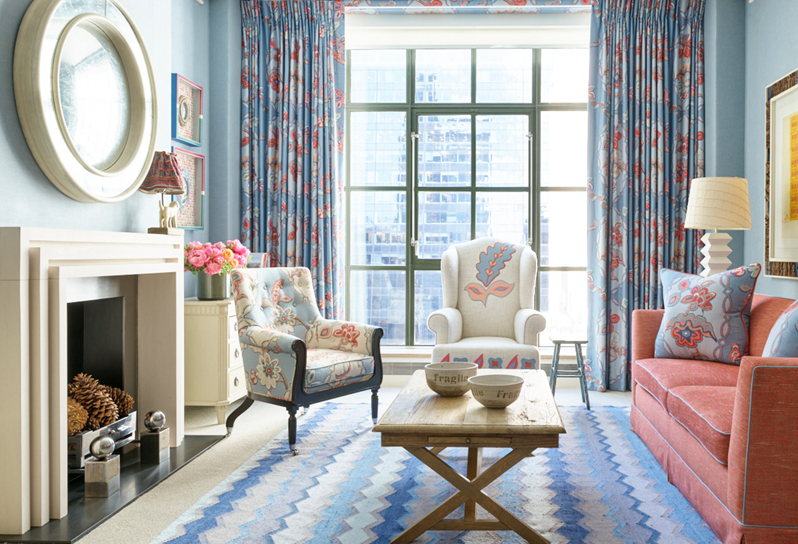 The drawing room of a Corner Terrace Suite which includes a sofa, two armchairs and a decorative rug with a vibrant design