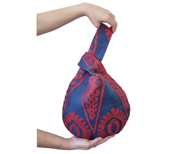 Hands holding loop hole bag in embroidered indigo fabric