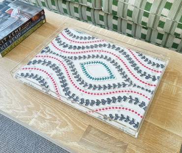 An acrylic tray in Villefranche fabric featuring mix of florals and geometrics with complementing stripes and textures, the seven designs in five colour groups combine embroidery and print.