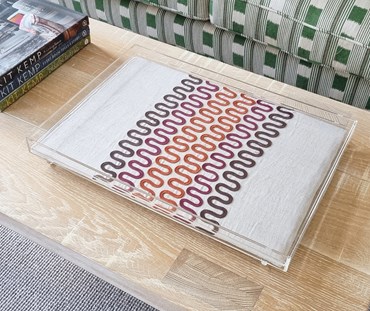 Acrylic Tray with orange, brown and pink squiggle applique work, on a coffee table.