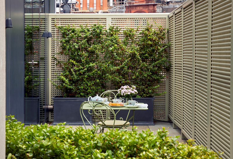 An outdoor terrace with a dining table and chairs