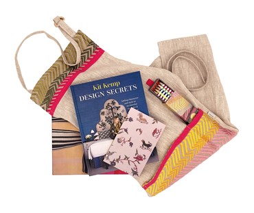 Boxed Gift , containing the pink bookend linen crafting apron (rolled), the "Design Secrets" By Kit Kemp, book, a box of pencils, and a green notebook.. everything you could need to get crafting.
