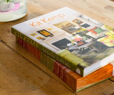 Kit Kemp's Design Thread Book shown on an oak dining table, on top of the slip cover.