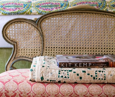 Kit Kemp's "A living Space" book, shown resting on a m antique end of bed bench, on a pile of antique blanks.