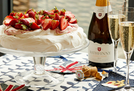 A pavlova with two glasses on English sparkling wine