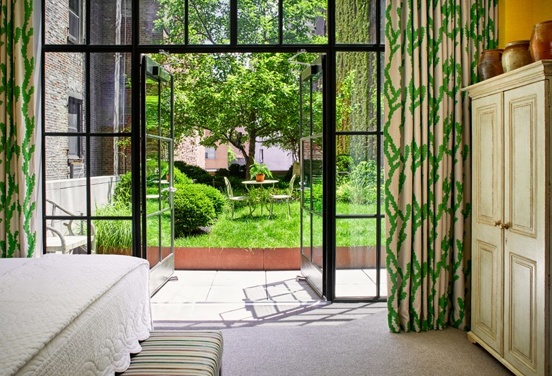 Loft style doors open to an outdoor terrace in the Meadow Suite at Crosby Street Hotel