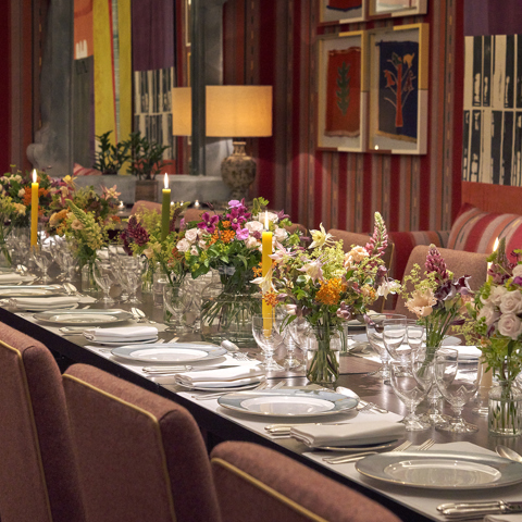 An image of the long dining table set up with flowers in the Sherwood private events room, at The Ham Yard Hotel.