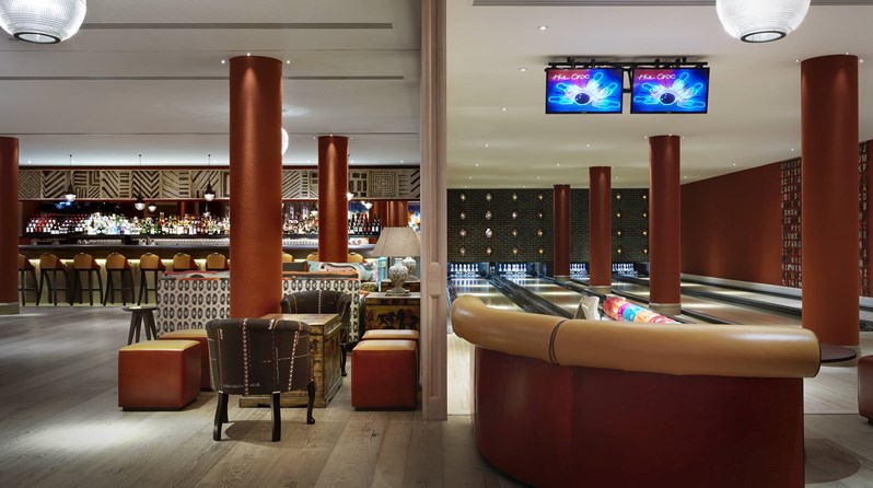 The Croc Bowling alley with it's four lanes of bowling spots with bowling balls in colorful balls, with a spacious open plan area with a bar at the back on the left hand side.