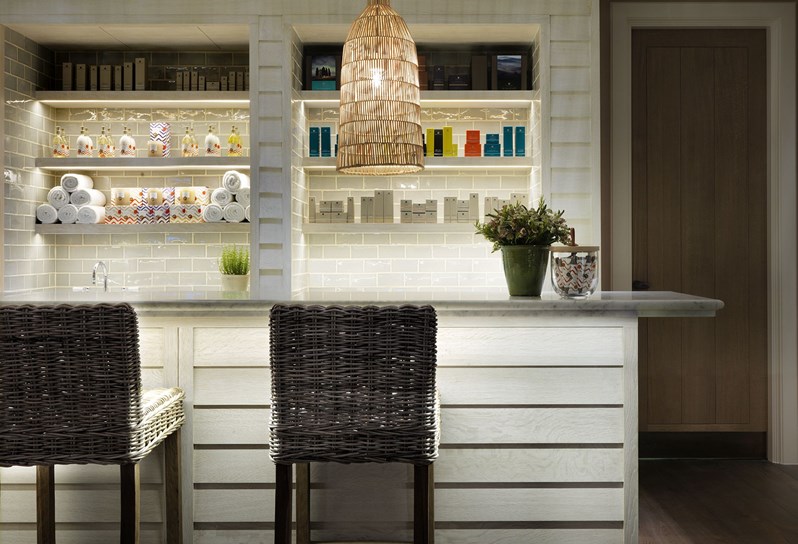 Soholistic Spa reception area with shelves behind stocking fresh towels, Rik Rak; Kit Kemp's range of exclusive bath products as well as Temple Spa bath products.