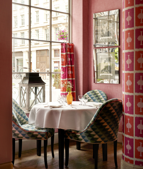 An image of the interior of Brumus Restaurant at Haymarket Hotel, focused on the tables set up for dining and the window behind.