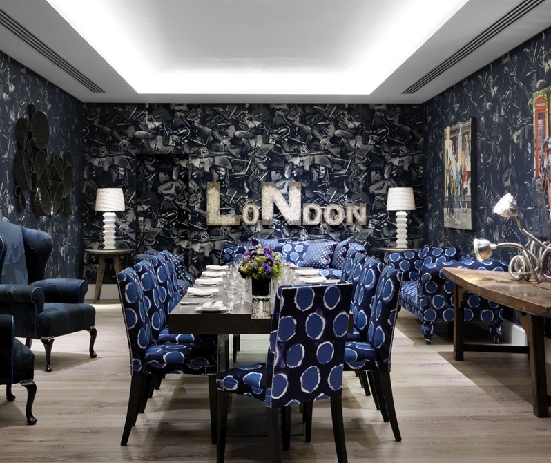 The Archer Room in blue tones with original John Paul Gaultier wallpaper, two comfortable armchairs and quirky design pieces surrounding a rectangular table set for private dining for 10 people on comfortable chairs matching the rest of the decor.