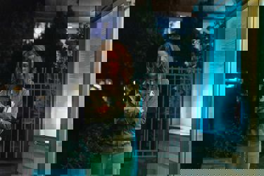 A still from "If I Had Legs" showing a woman holding a glass and bottle. 