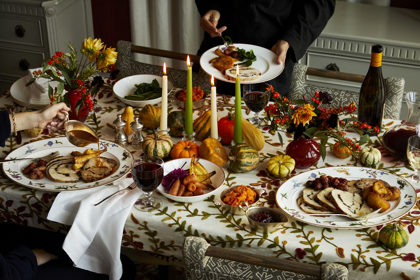 Wide shot of a Thanksgiving dining table with guests