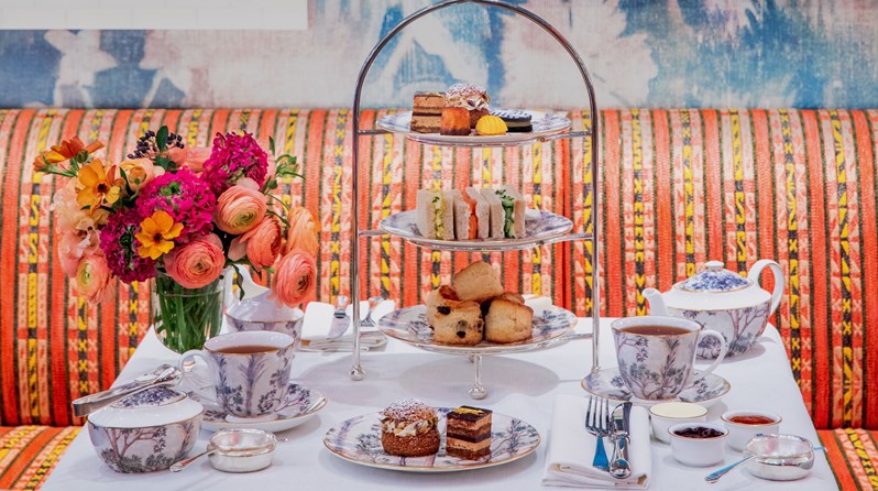 An Afternoon Tea with fruit scones, clotted cream and preserves with small pastries and finger sandwiches with tea in a Tall Trees teapot and tea cup at the bar and restaurant at Warren Street Hotel
