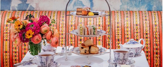 An Afternoon Tea with fruit scones, clotted cream and preserves with small pastries and finger sandwiches with tea in a Tall Trees teapot and tea cup at the bar and restaurant at Warren Street Hotel