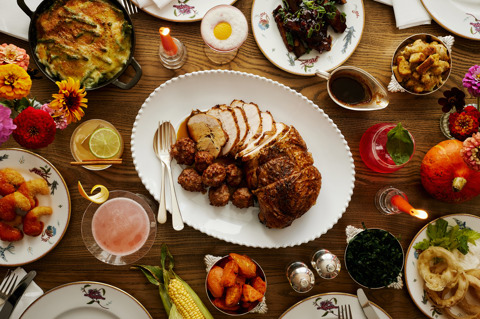 This image is shot from above in Oscar, at Charlotte Street Hotel, to promote the thanksgiving menu friendsgiving. The image shows multiple dishes from the menu including turkey, onion rings, ribs, roast vegetables, mac and cheese and lots of the themed cocktails.
