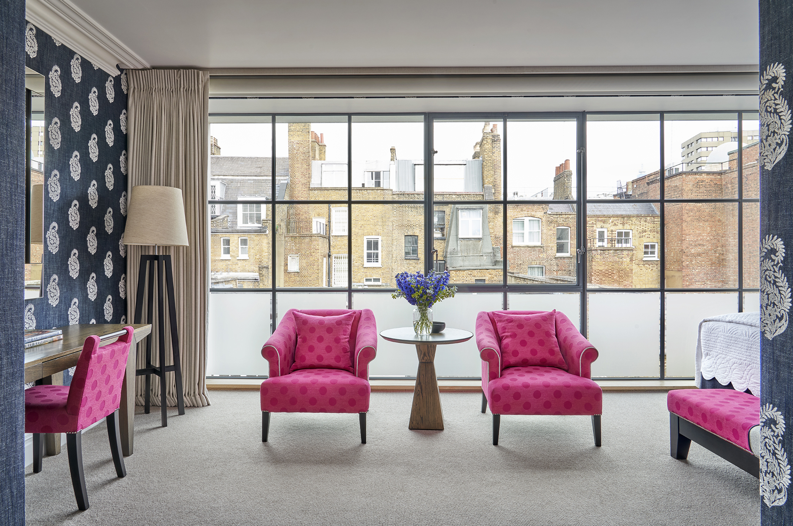 Pink armchairs and table by large window
