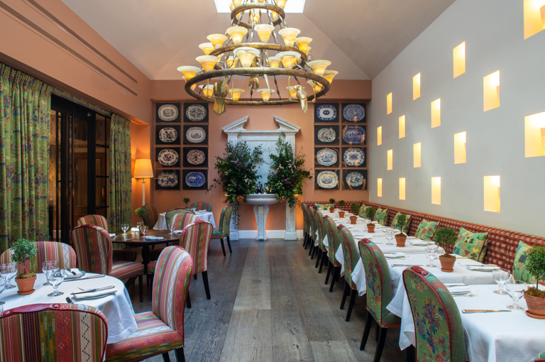 Wide shot of square and round dining tables set-up in the Orangery private events room at the Whitby Hotel