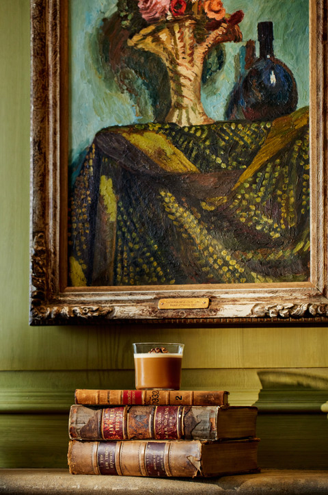 A close-up portrait shot of the Cafe Bell cocktail from the Bloomsbury Group cocktail collection, in front of a painting by Vanessa Bell, at Oscar Bar & Restaurant