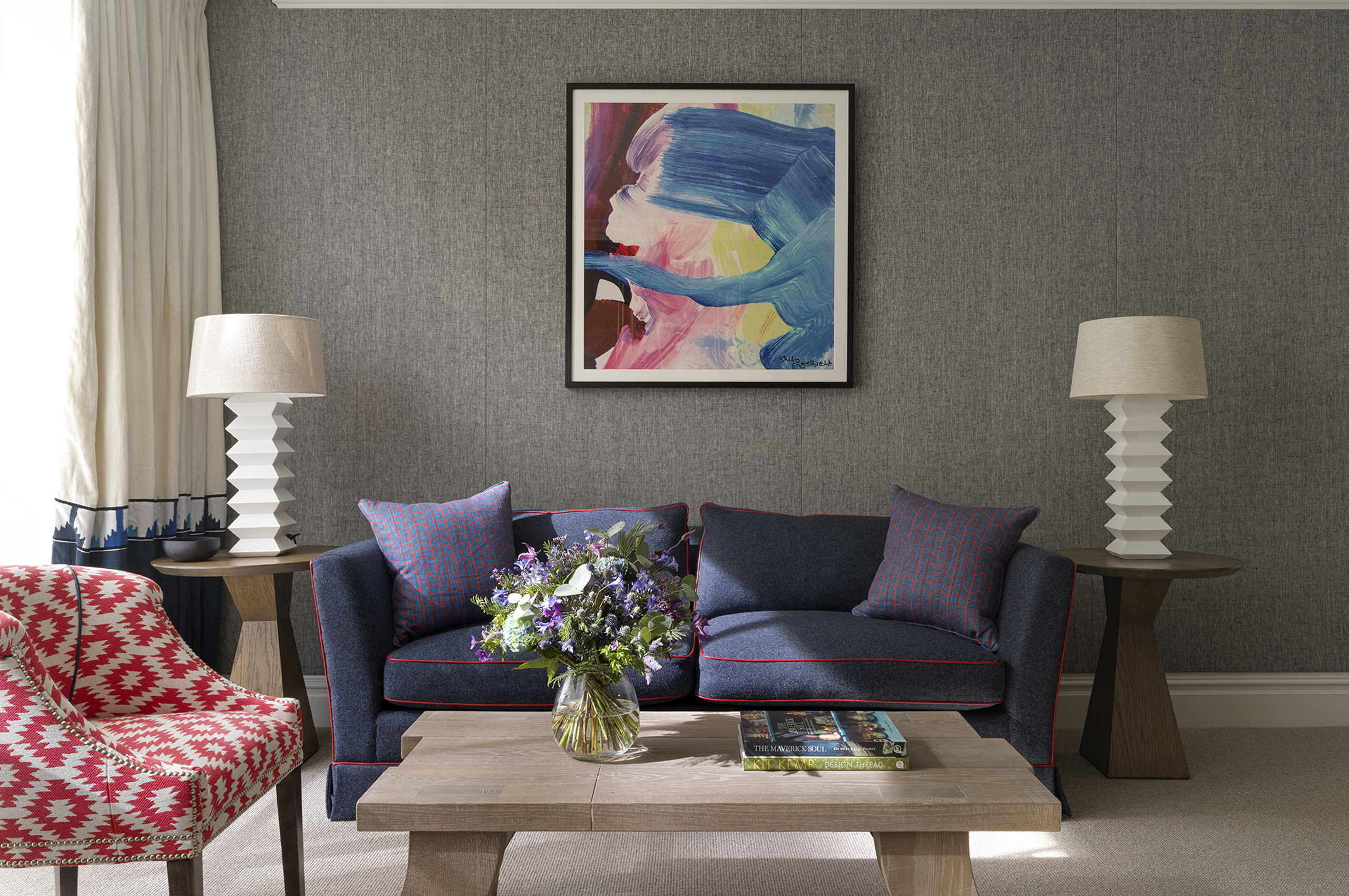 Modern hotel suite living room with navy sofa and artwork