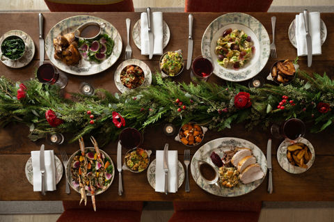 This a landscape image of a festive dining scene at the Warren Street Bar, Warren Street Hotel, featuring different dishes from the festive menu including a seasonal pasta dish and a traditional roast dinner served on Tall Tress Fine Bone China.