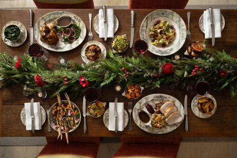 This a landscape image of a festive dining scene at the Warren Street Bar, Warren Street Hotel, featuring different dishes from the festive menu including a seasonal pasta dish and a traditional roast dinner served on Tall Tress Fine Bone China.