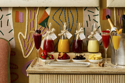 A wide angle shot of the Bellini bar in the Dora Carrington Room at Charlotte Street Hotel: the bar is set up with four flavoured Bellinis, a selection of garnishes, and a bottle of Champagne