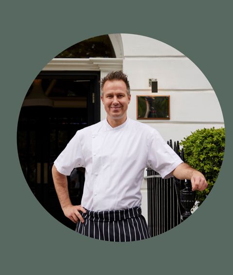 A portrait shot of Tamas Kalmar, Head Chef at The Potting Shed, standing outside the entrance to Dorset Square Hotel