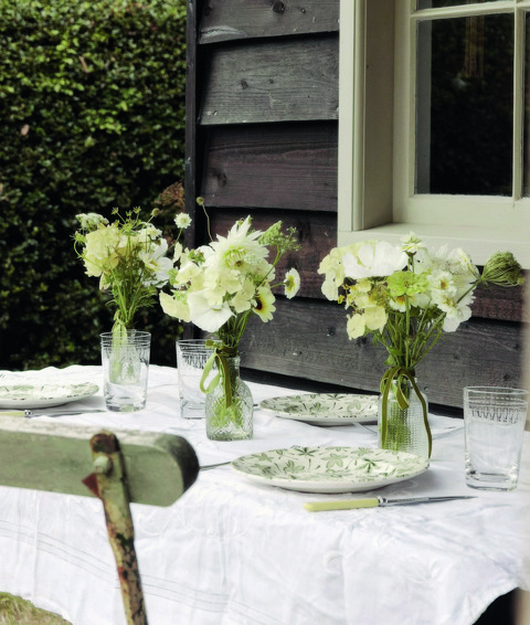 An image to promote Harriet Thystlethwaytes new book 'A country style: living and creating with nature through the seasons' the image shows a beautifully set table with flower arrangement from Harriet's garden.