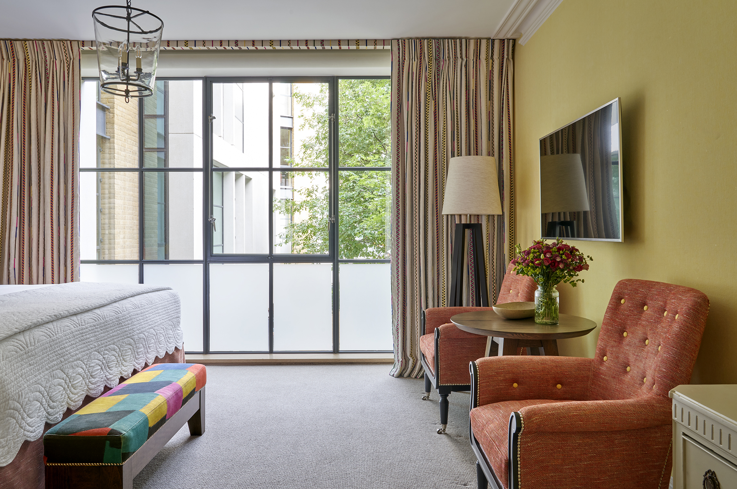 Hotel bedroom with seating area and large window