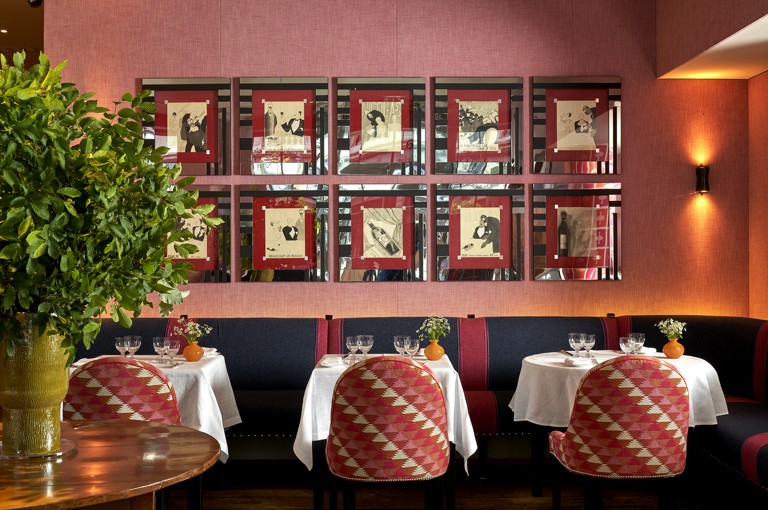 Side shot of Brumus Restaurant dining tables and artwork at Haymarket Hotel