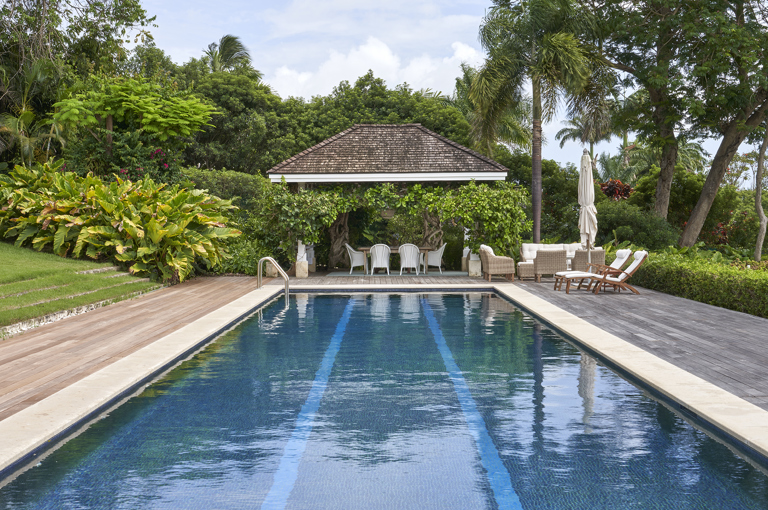 An image from the end of the pool of the terrace at the side of the pool used for dining. At Rossferry, the Caribbean property manged by Firmdale.