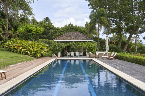 An image from the end of the pool of the terrace at the side of the pool used for dining. At Rossferry, the Caribbean property manged by Firmdale.