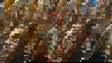 Still from the film Blue Moon. A close up of a woman holding some roses looking down at a man pleading towards her