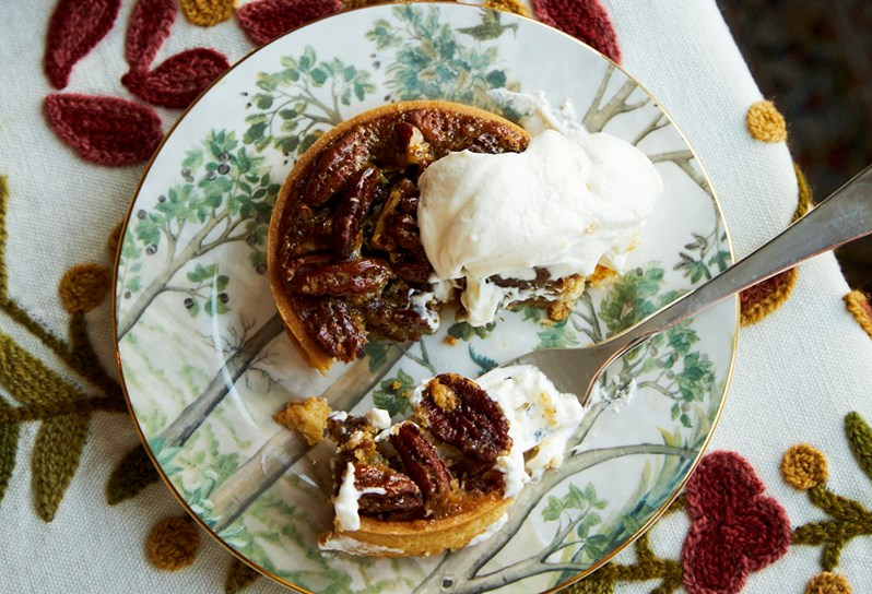 Small pecan pie with a fork having taken a small bit out