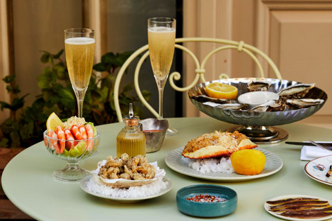 Multiple seafood dishes shot on the patio at Charlotte Street Hotel. Including Oysters, Crab, other seafood dishes and glasses of champagne. 