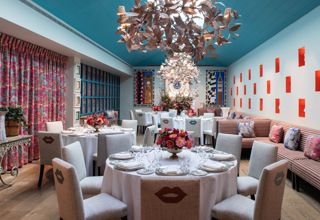 A Round dining tables set-up with dinnerware and glassware showcasing a chandelier and Orangery private events room at Warren Street Hotel