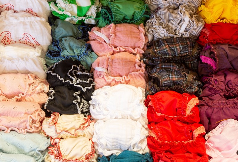 A close up shot of small colourful clothes rolled up and packed together.
