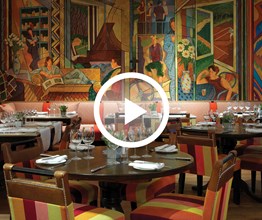 Oscar Bar and Restaurant at Charlotte Street Hotel with a vibrant wall mural. Overlaid on the image is a play button icon.