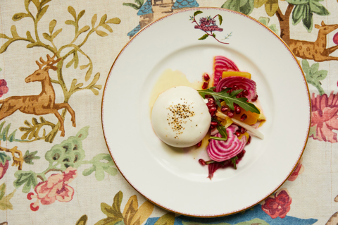 Close up shot of Burrata taken from above, on a tablecloth with a coloured design 