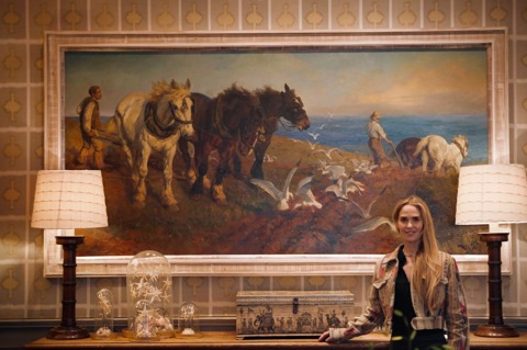 Firmdale Art Ambassador and Design Director Willow Kemp standing in front of a large painting in the Drawing Room at Ham Yard Hotel