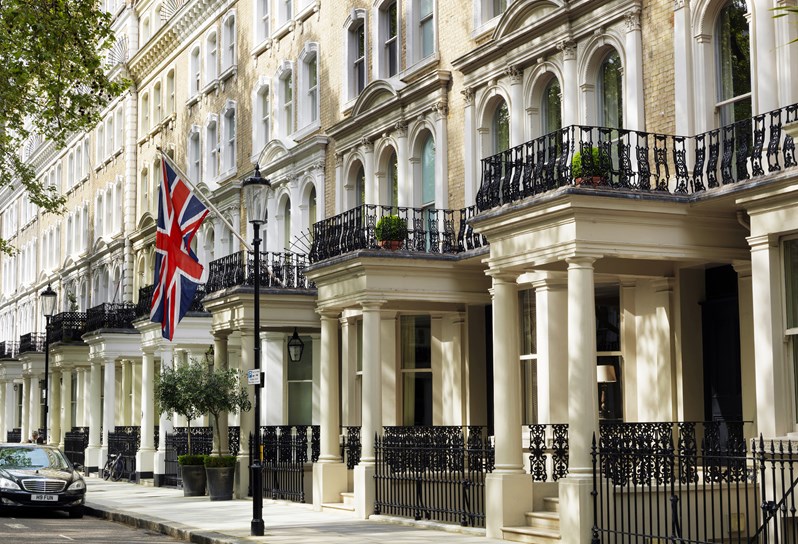 Beautiful townhouses in Knightsbridge, with a British flag and two large flower pots signalling the entrance to Knightsbridge Hotel.