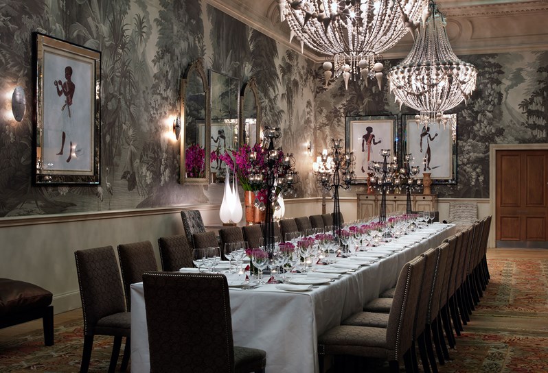 A long table for an intimate private dinner for 16, set with Kit Kemp's own range Mythical Creatures from Wedgwood, complete with flower arrangement and candles, in the stunning setting of the Shooting Gallery Private Room.