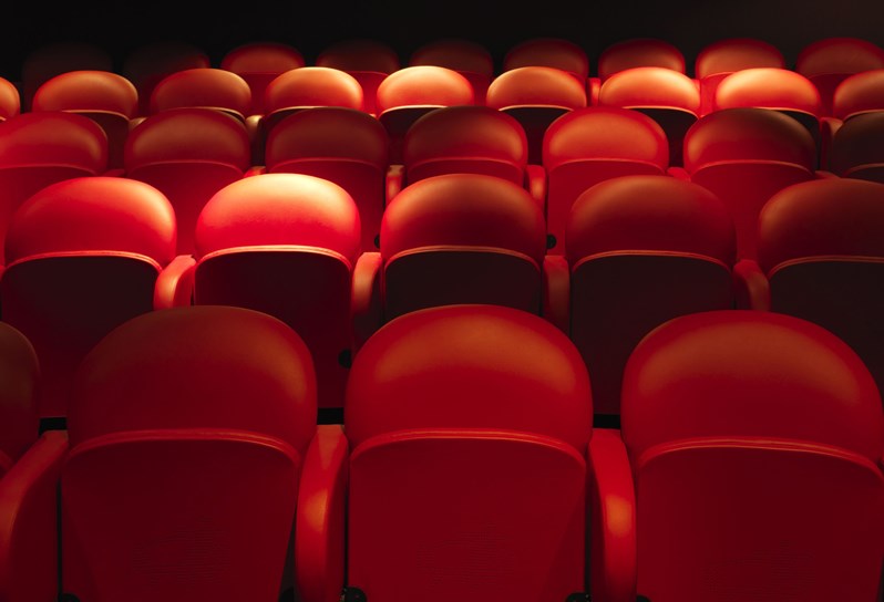 The Screening Room at Covent Garden Hotel. Rows of red cinema style chairs point towards a screen.